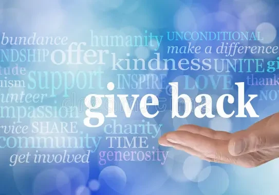 Hand offering the phrase 'give back' surrounded by kindness-related words.