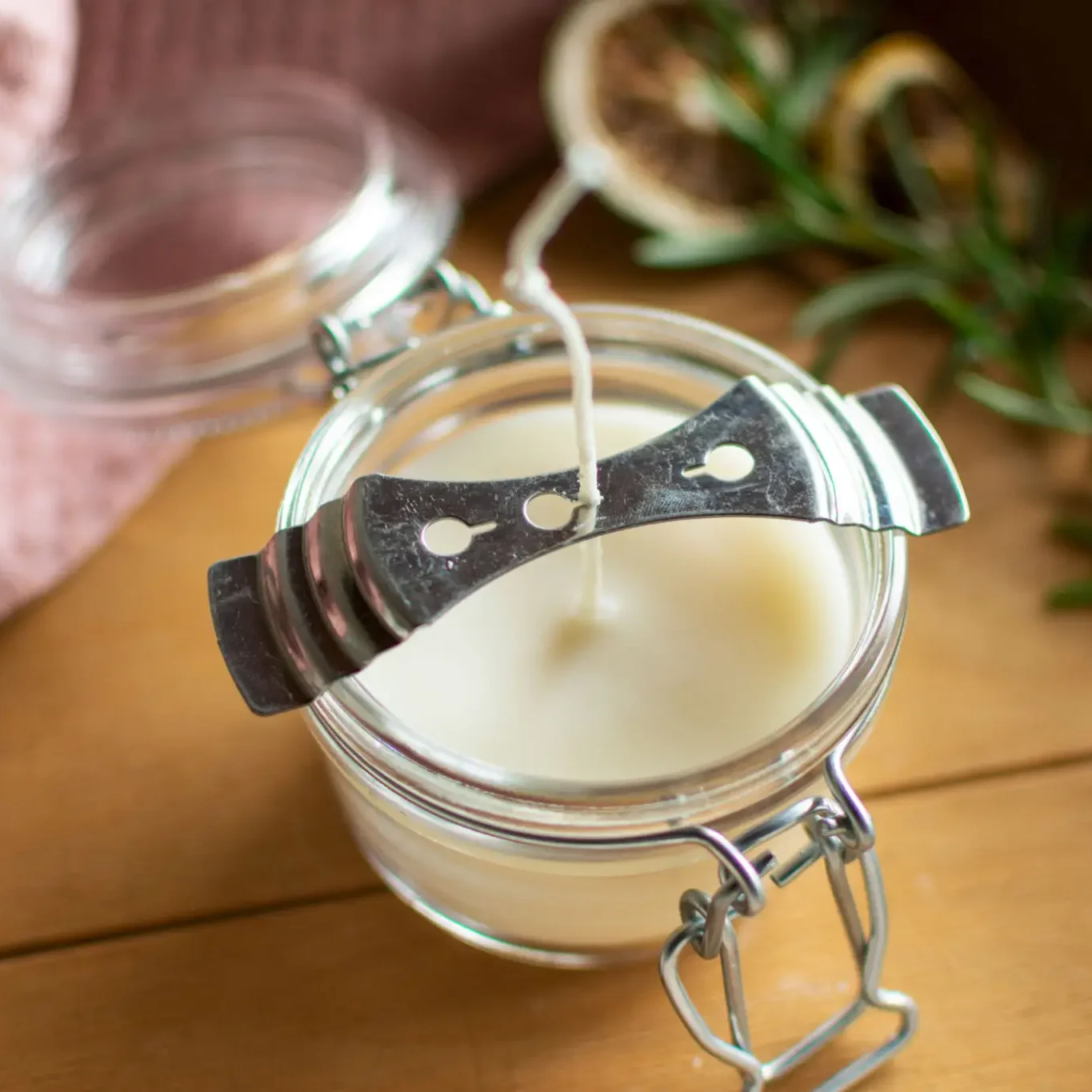 A glass jar of white cream with a wooden spatula on top.